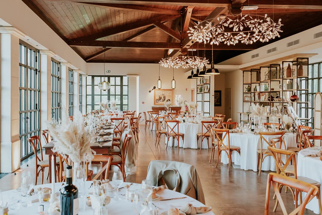 Salle de domaine sous lustre floral et poutres apparentes